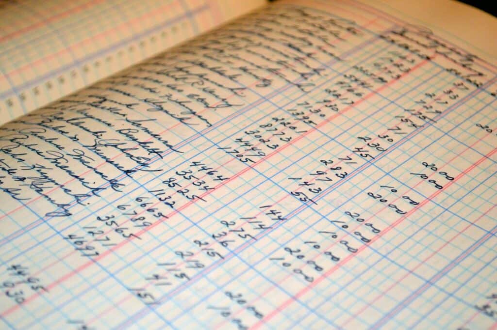 10 Reasons Your Small Business Needs a Bookkeeper And How to Choose One 5 Close-up of a vintage handwritten ledger detailing financial records and accounts.