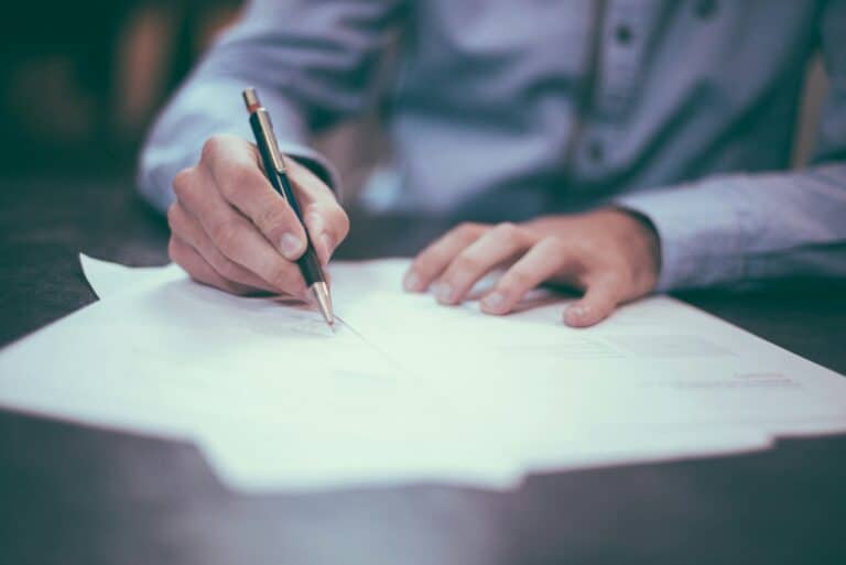 man writing on paper Finance Broker