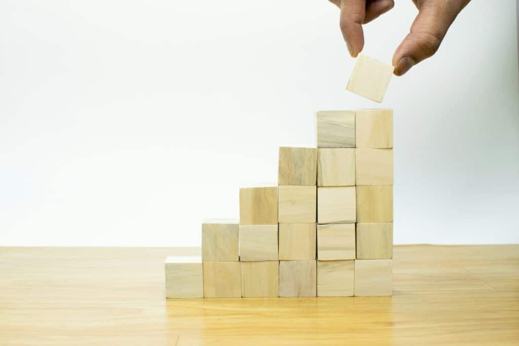 What is Net Profit? Essential Guide to Understanding and Calculation 1 A person placing a piece of wood into a pyramid